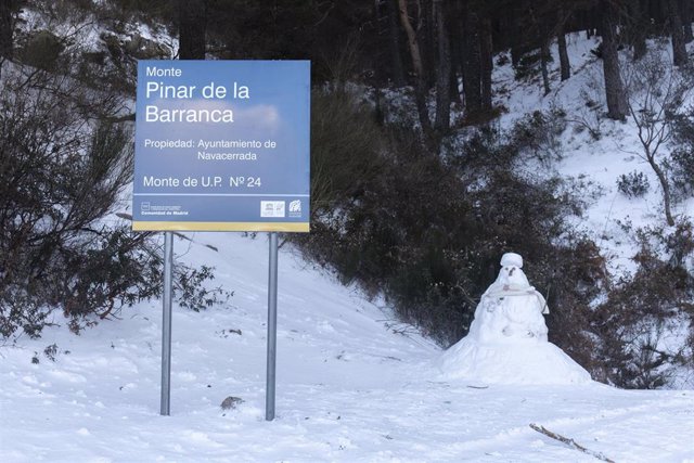 Archivo - Un muñeco de nieve junto a un cartel indicador en el Puerto de Navacerrada, a 19 de enero de 2023, en Navacerrada, Madrid (España). La Agencia de Seguridad y Emergencias de la Comunidad de Madrid (ASEM 112) ha activado la situación 0 de la fase 