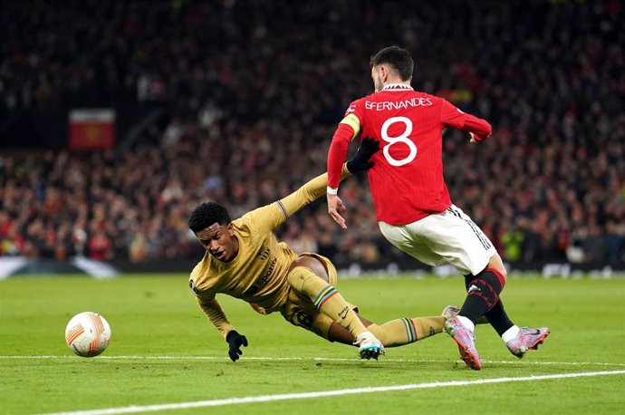 23 February 2023, United Kingdom, Manchester: Manchester United's Bruno Fernandes (R)and Barcelona's Alex Balde fight for the ball during the UEFA Europa League soccer match between Manchester United and Barcelona at Old Trafford