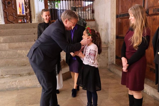 El president de la Generalitat, Ximo Puig, saluda a una niña ucraniana