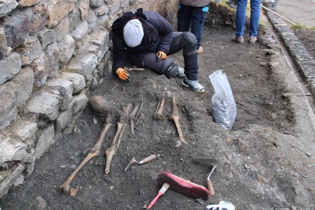 Uno de los arqueólogos examinando los restos humanos hallados en el exterior de la iglesia de Sant Joan de Caselles
