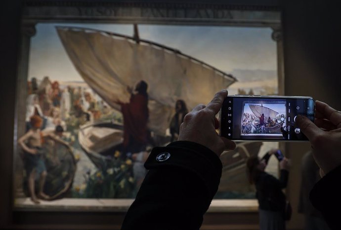 Una persona fotografía una de las obras del acto de constitución de la Comisión Conmemorativa del Año Joaquín Sorolla, en el Palacio de las Comunicaciones