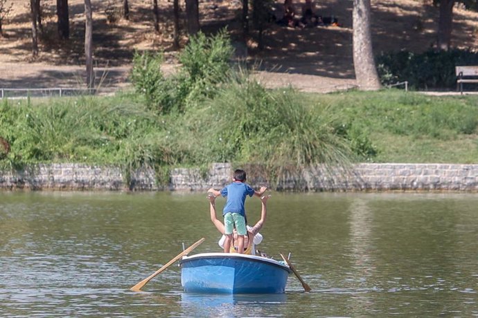 Archivo - Un niño juega con otra persona en una barca alquilada del lago de la Casa de Campo, a 21 de agosto de 2022, en Madrid (España).