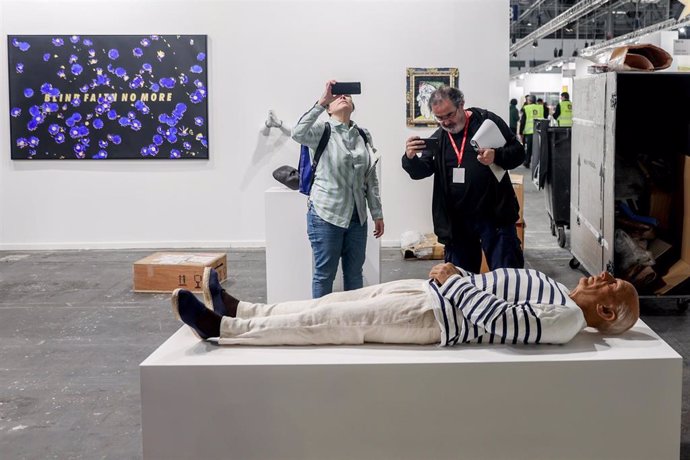 Dos personas fotografían una escultura del pintor Pablo Picasso en ARCO 2023, en Feria de Madrid IFEMA de Madrid