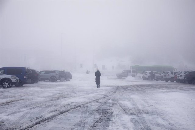 Archivo - Una persona camina por la nieve en el parking del Puerto de Navacerrada, a 19 de enero de 2023, en Navacerrada
