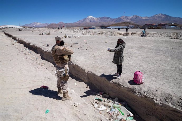 Archivo - Una migrante venezolana muestra su documento de identidad a un soldado del ejército chileno en Colchane (Chile), localidad situada a pocos kilómetros de Bolivia (ARCHIVO)