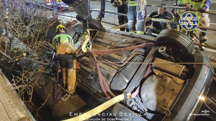 Rescate de los Bomberos de un coche que se salió de la vía y quedó suspendido a siete metros de altura en la avenida de las Ciencias en Sevilla.