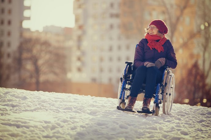 Archivo - Mujer en silla de ruedas en un parque en invierno.