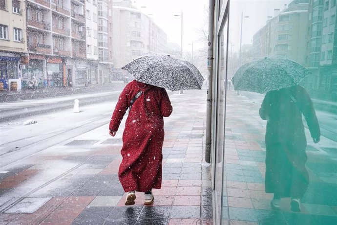 Archivo - Una mujer se refugia de la nieve con un paraguas en Vitoria-Gasteiz, a 18 de enero de 2023, en Vitoria
