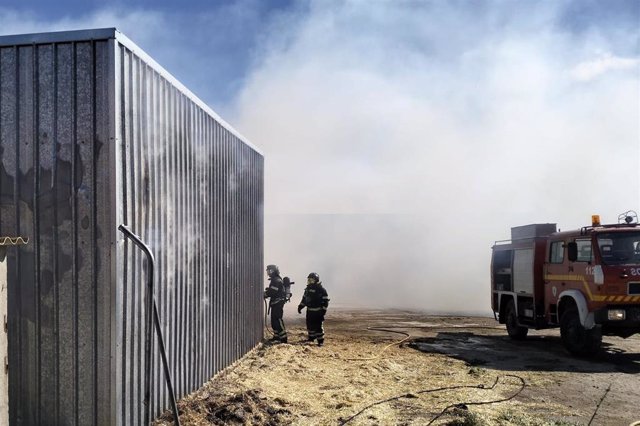 Los Bomberos de Ávila trabajan para extinguir un fuego declarado en una nave agrícola en Las Navas del Marqués