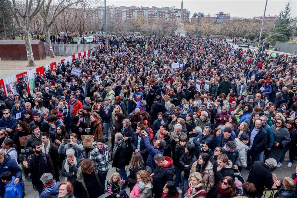 Varias personas porta una pancarta que reza 'Ni uno menos, salvemos Madrid' en la concentración para defender la arboleda de la zona de Madrid Río, que se verá afectada por las obras del Metro