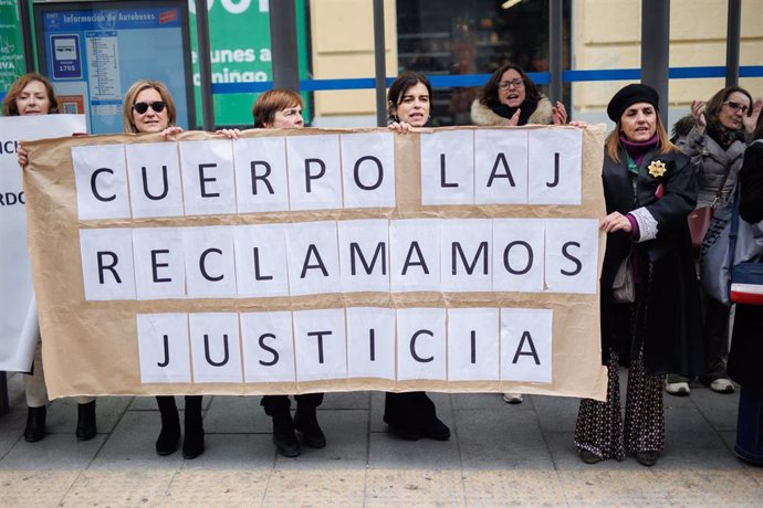 Varias mujeres sujetan una pancarta de 'Cuerpo Laj, reclamamos justicia' a las de la sede del Ministerio donde se reúnen el comité de huelga de los Letrados de Justicia y el Ministerio, a 27 de febrero de 2023, en Madrid (España). Esta es la tercera vez