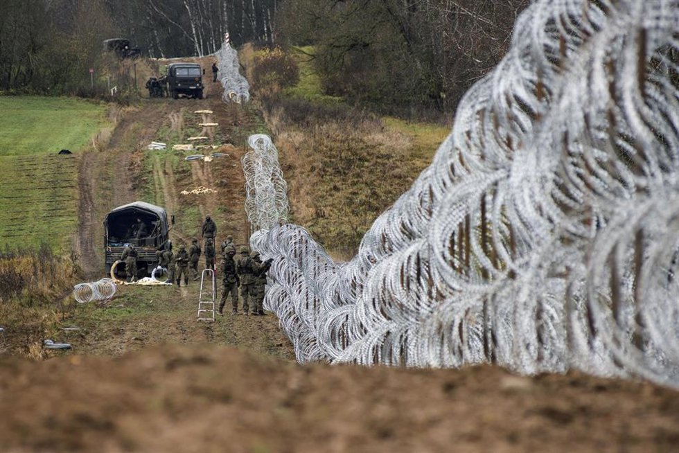 Archivo - Militares polacos colocan una valla en la frontera