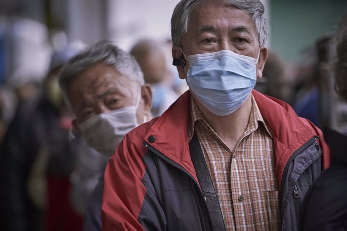 Archivo - Un grupo de personas hace cola en Hong Kong para obtener mascarillas.