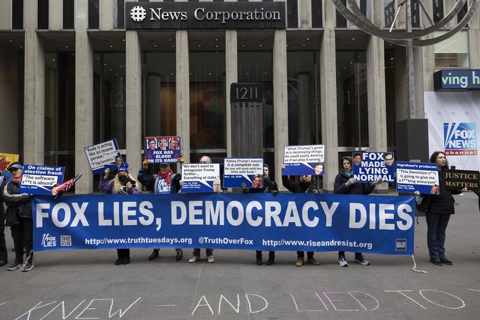  Manifestantes sostienen pancartas frente a Fox News Channel durante una protesta contra la cadena, en Nueva York