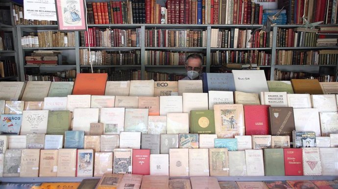 Archivo - Un vendedor trabaja en su puesto en el Mercado de libros de la Cuesta Moyano