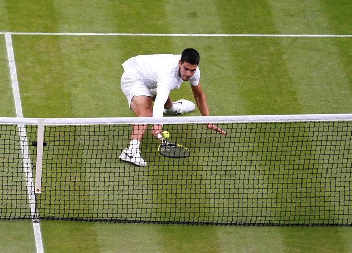 Archivo - Carlos Alcaraz intenta devolver una pelota en Wimbledon 2022