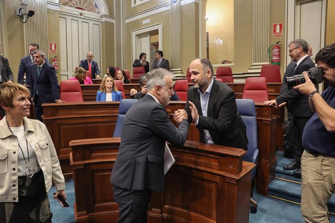 El presidente de Canarias, Ángel Víctor Torres (i), y el consejero de Transición Ecológica, Lucha contra el Cambio Climático y Planificación Territorial, José Antonio Valbuena (d), se saludan en el 'Debate sobre el Estado de la Nacionalidad'