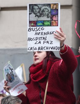 Archivo - Una mujer sujeta un cartel en que se lee 'Busco hermano Hospital La Paz caso archivado', en la concentración estatal de bebés robados frente a la Fiscalia General del Estado, Madrid (España), a 27 de enero de 2020.