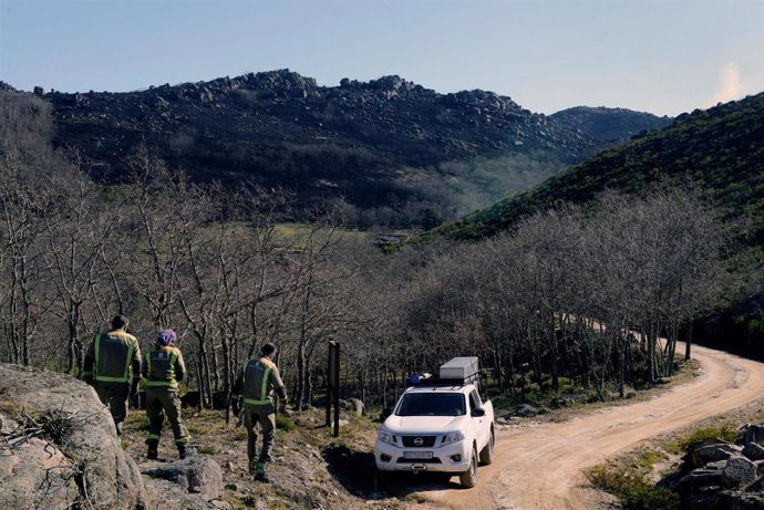 Trabajadores forestales observan el incendio forestal en el pueblo de Salgueiros, a 7 de febrero de 2023, en Muíños, Ourense, Galicia (España). La Consellería de Medio Rural de Galicia ha informado de un incendio forestal activo, originado en Portugal, 