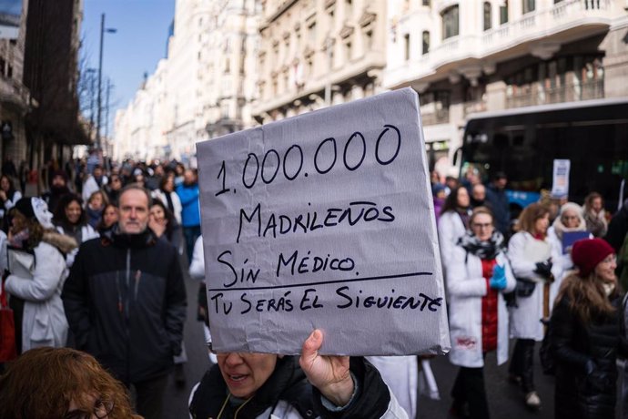 Una mujer sujeta un cartel en el que se lee: '1.000.000' madrileños sin médico', durante una manifestación de facultativos hospitalarios 