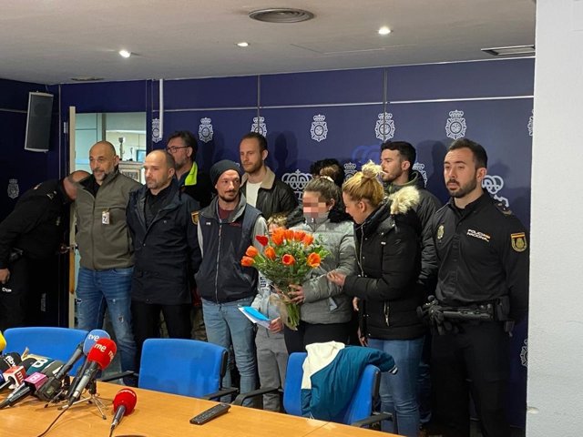 La familia rescatada junto a los agentes y bomberos implicados en el rescate.
