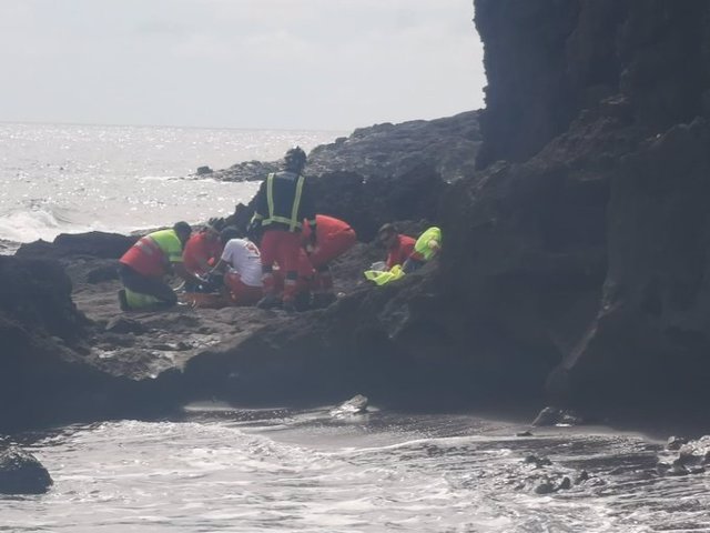 Personal de Cruz Roja y bomberos rescatan al afectado tras caerse en una zona de rocas en Montaña Roja, en la costa del municipio de Granadilla de Abona