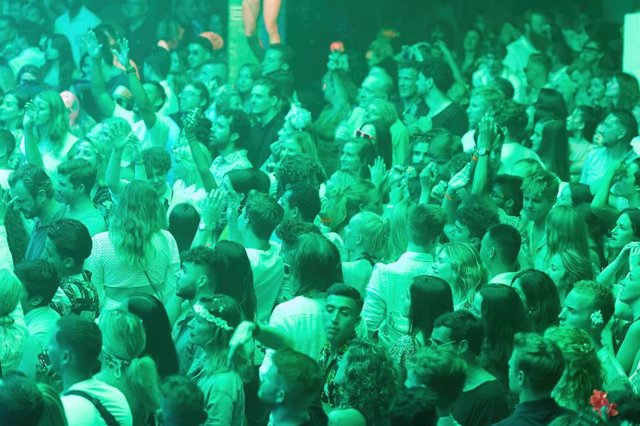Archivo - Decenas de personas asisten a una fiesta en una discoteca.