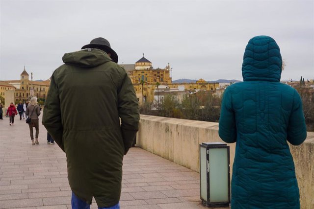 Archivo - Transeúntes y turistas por el famoso puente de San Rafael con vistas a la Mezquita  en el primer día intenso de frío  a 16 de enero de 2023 en Córdoba (Andalucía, España).