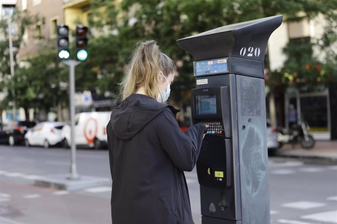 Archivo - Una joven utiliza un parquímetro del Servicio de Estacionamiento Regulado (SER) de Madrid 