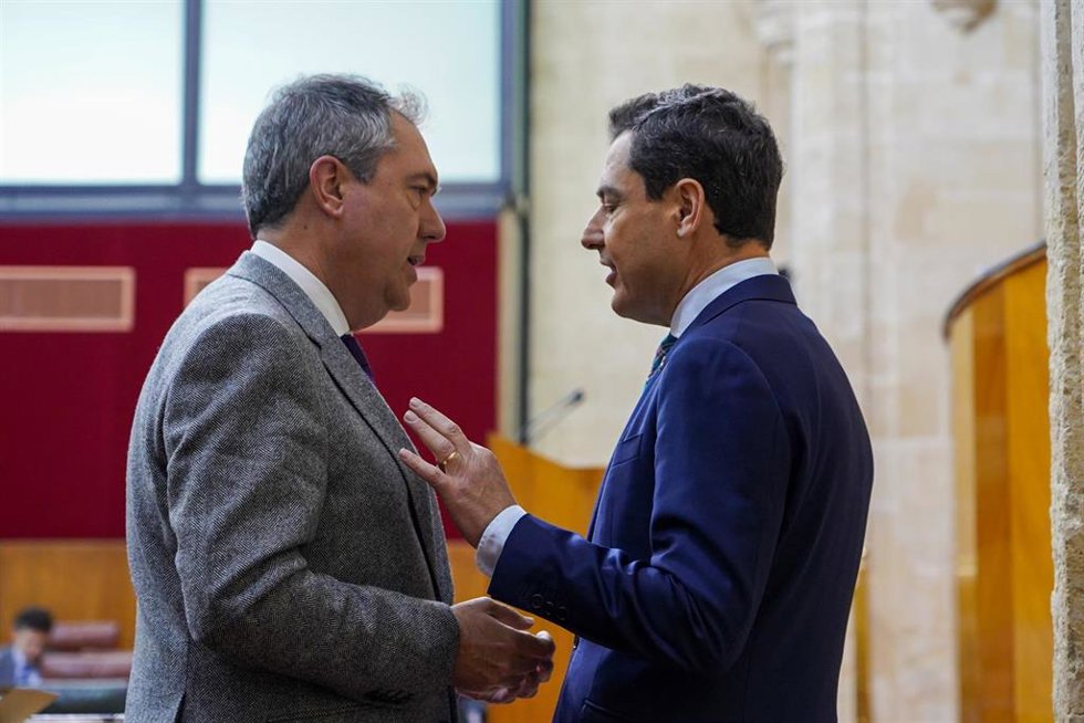 El presidente de la Junta de Andalucía, Juanma Moreno, (d) dialoga con el secretario general del PSOE de Andalucía y presidente del Grupo Parlamentario Socialista, Juan Espadas, (i) en el Parlamento andaluz (Foto de archivo).