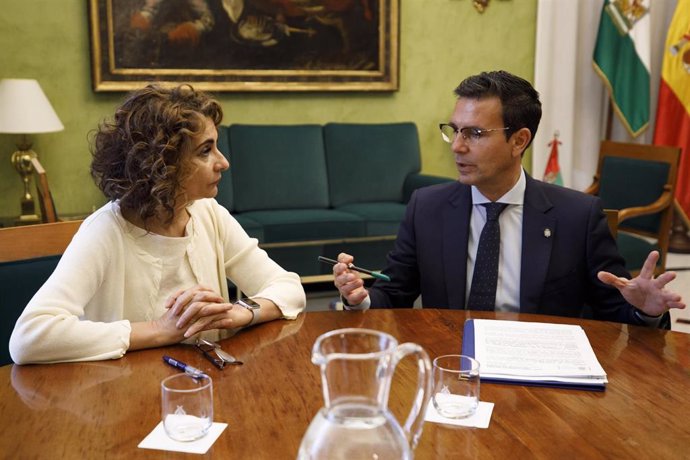 La ministra de Hacienda y Función Pública, María Jesús Montero (i) junto al alcalde de Granada, Francisco Cuenca (d), en el Ayuntamiento de Granada