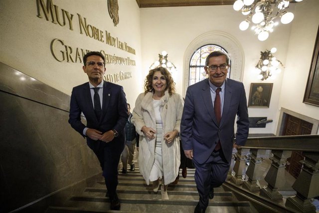 La ministra de Hacienda y Función Pública, María Jesús Montero (c); junto al alcalde de Granada, Francisco Cuenca (i); y el presidente de la Diputación, José Entrena (d), durante su visita al  Ayuntamiento de Granada. 