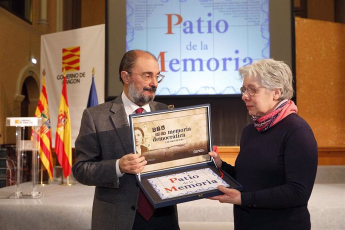 El presidente del Gobierno de Aragón, Javier Lambán, y una familiar de los homenajeados, con la placa del Patio de la Memoria, instalada en el Edificio Pignatelli.