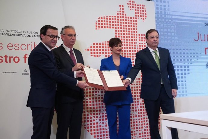 La ministra de Política Territorial y portavoz, Isabel Rodríguez; el presidente de la Junta, Guillermo Fernández Vara, y los alcaldes de Don Benito y Villanueva de la Serena, José Luis Quintana y Miguel Ángel Gallardo, firman el protocolo de fusión
