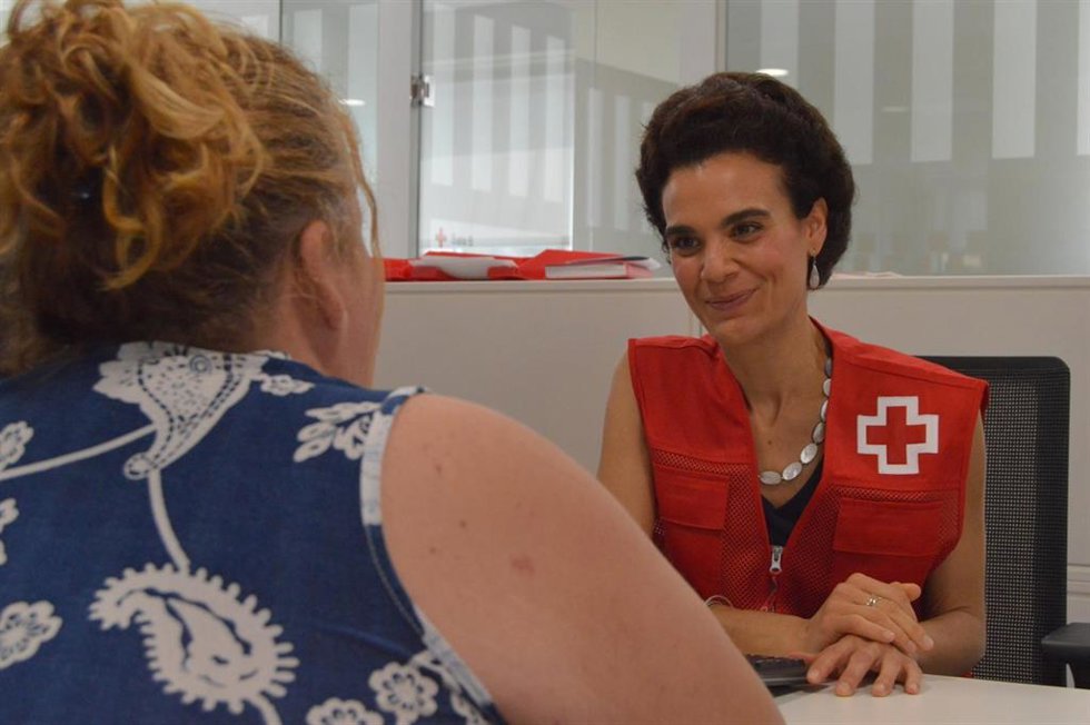 Una voluntaria de Cruz Roja presta atención a una mujer.