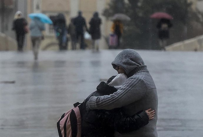 Una pareja se abraza mientras llueve, a 6 de febrero de 2023, en Valencia, Comunidad Valenciana (España).