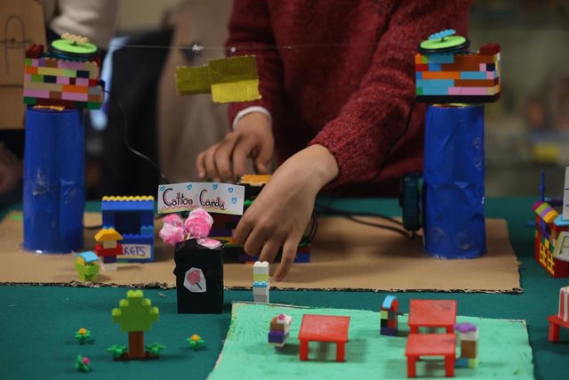 Varios alumnos con un proyecro del colegio público Laura García Noblejas y Brunet, en una feria con proyectos expuestos de colegios en la Ciudad Escolar Cantoblanco.