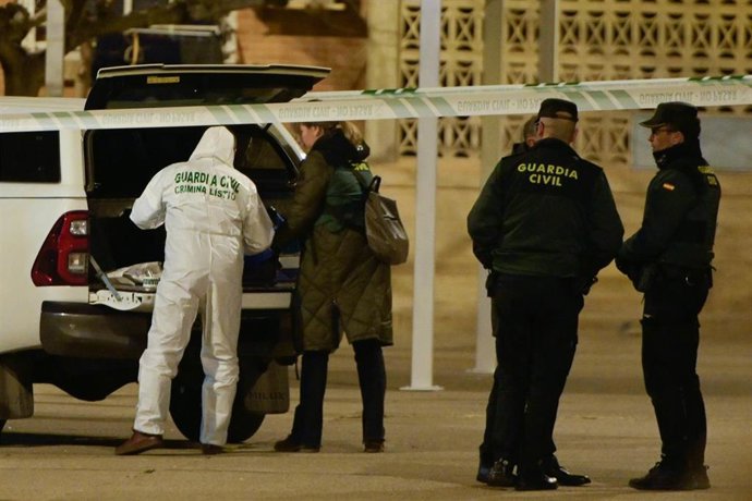 Guardias civiles frente al portal del edificio de la mujer fallecida en Villanueva de Gállego (Zaragoza).