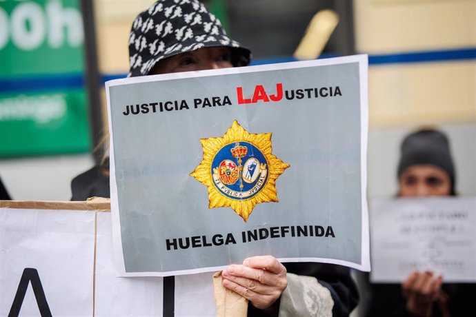 Una mujer sujeta una pancarta de 'Justicia para LAJusticia' a las puertas de la sede del Ministerio donde se reúnen el comité de huelga de los Letrados de Justicia y el Ministerio.