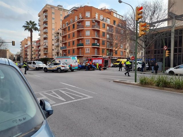Un policía dirige el tráfico en Palma con motivo de que una ambulancia ha volcado tras chocar con un turismo en la calle calle Joan Massanet i Moragues, esquina con General Riera