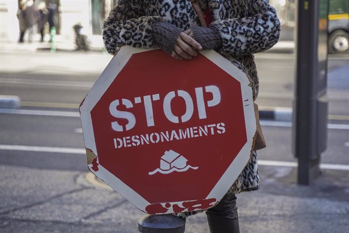 Una persona sujeta un cartel de 'Stop desnonaments'