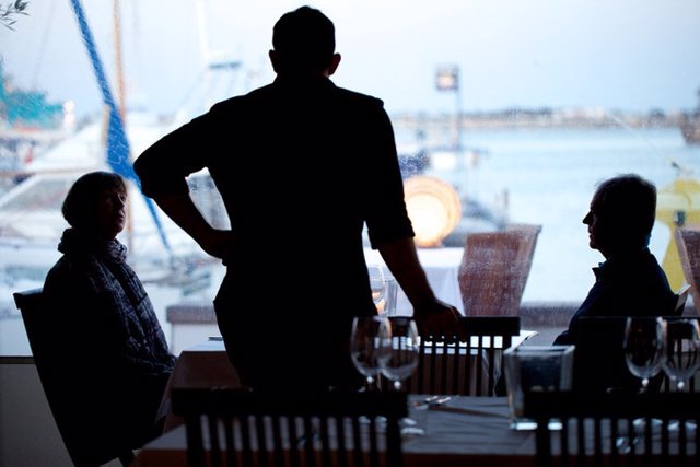 Archivo - Un camarero, de espaldas, sirviendo a unos comensales en Formentera.