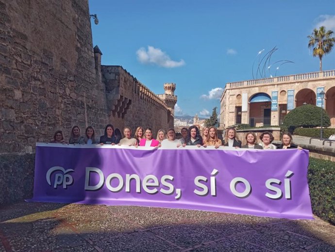 La presidenta del PP de Balearea, Marga Prohens, junto a otras mujeres del partido, posa con una pancarta por el Día de la Mujer.