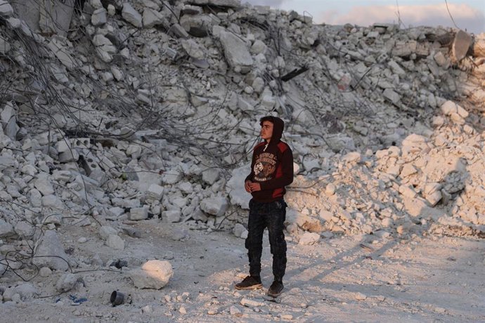 Un adolescente junto a los escombros de un edificio destruido por los terremotos en Al Atarib, Siria