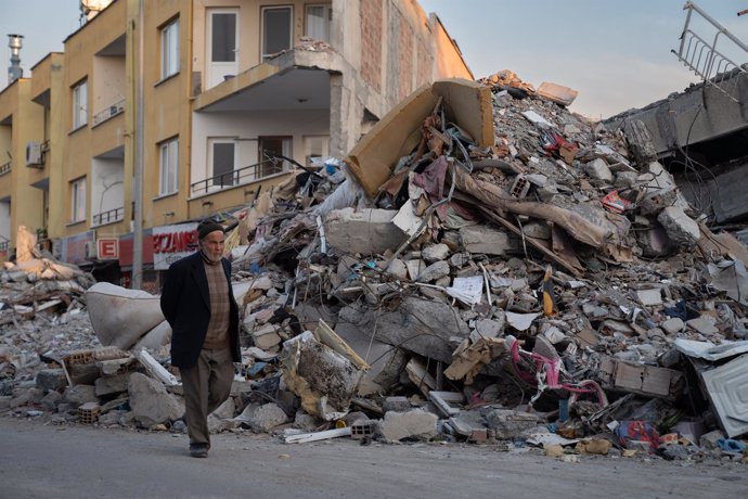 Un hombre camina entre los escombros de los edificios derribados por el terremoto, en Iskenderun, Turquía.