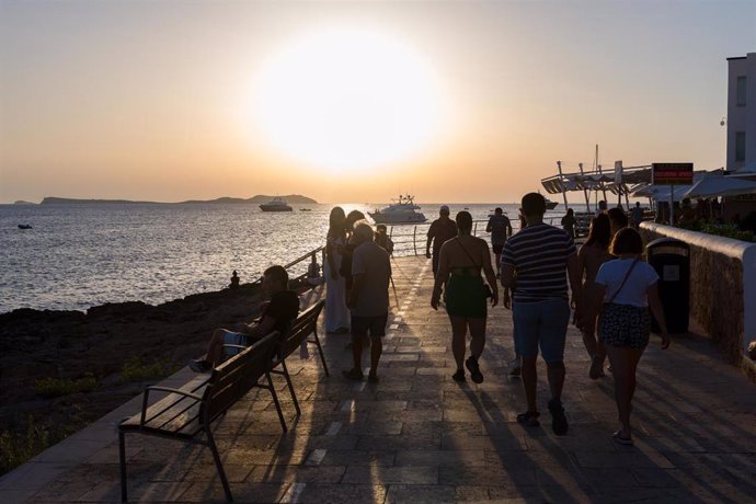 Archivo - Turistas en Ibiza contemplando la puesta de sol.
