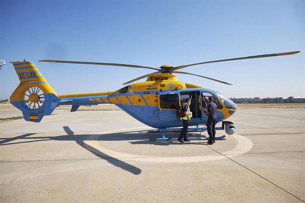 Archivo - Un operario y un militar tras el aterrizaje de uno de los helicópteros Pegasus de la DGT 