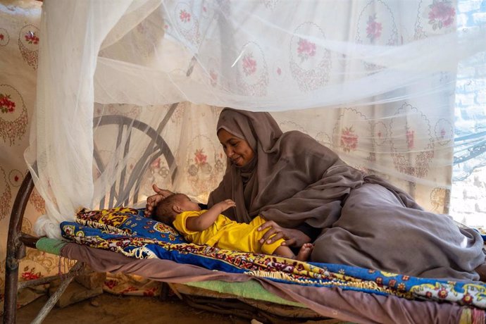 Una mujer beneficiaria de un programa de ayuda de UNICEF yace junto a su hijo en la localidad de Wager, en el estado sudanés de Kassala