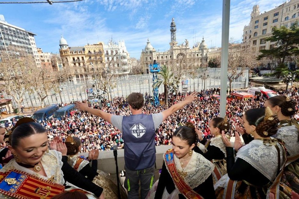 Imagen del saludo desde el balcón del Ayuntamiento de Valncia de uno de los miembros de la pirotecnia Lluch, encargada de la séptima 'masclet' de las Fallas de 2023, tras el disparo.