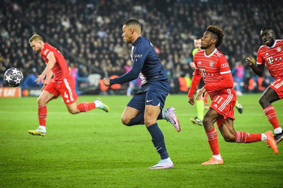 Kylian Mbappe conduce la pelota perseguido por Kingsley Coman en el PSG-Bayern de la Liga de Campeones 2022-2023